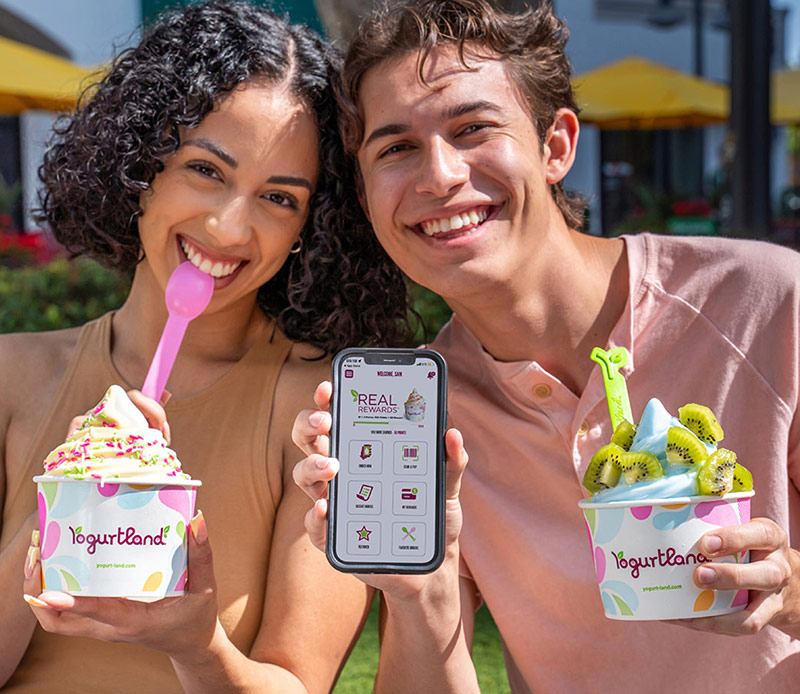 Two people using the Yogurtland Real Rewards app.